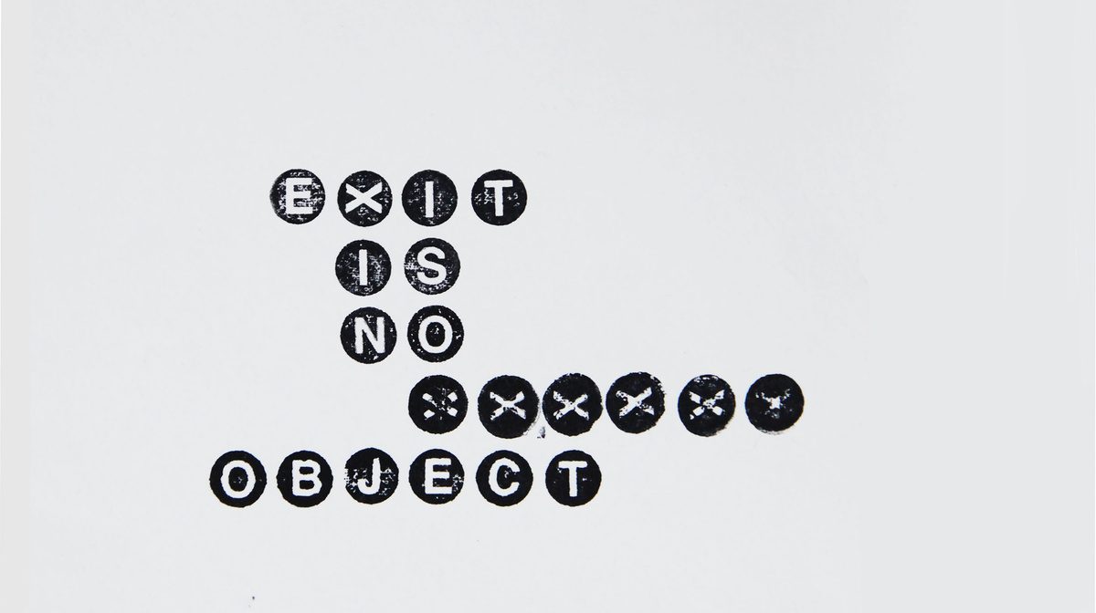 The title Exit is No Object spelled in small circular badge letters on a white wall