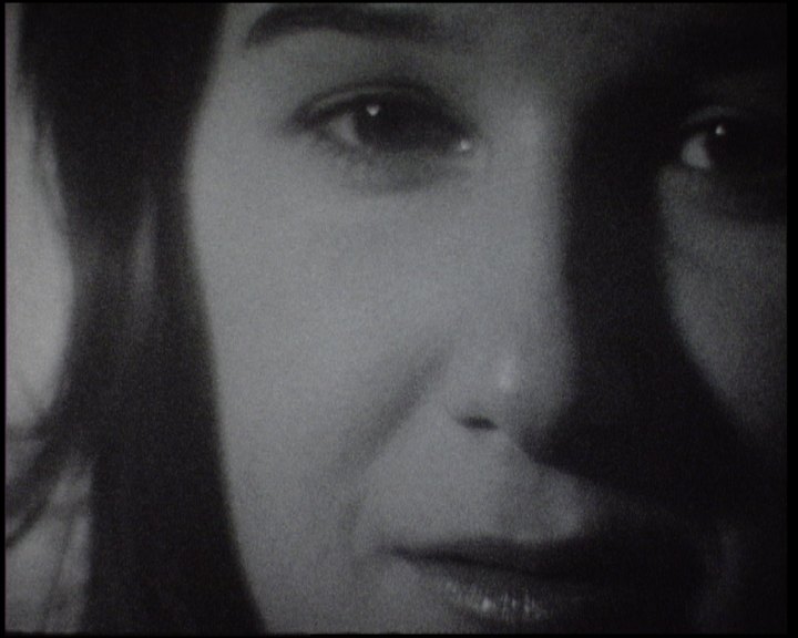 A woman's face from the eyes down, dark hair on both sides, lit from the right