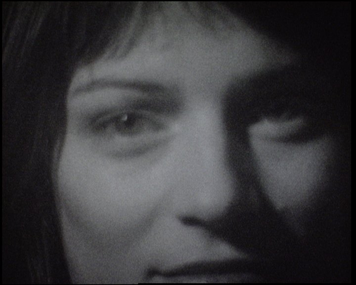 A woman with a fringe looking down and to the side, her eyes in soft focus