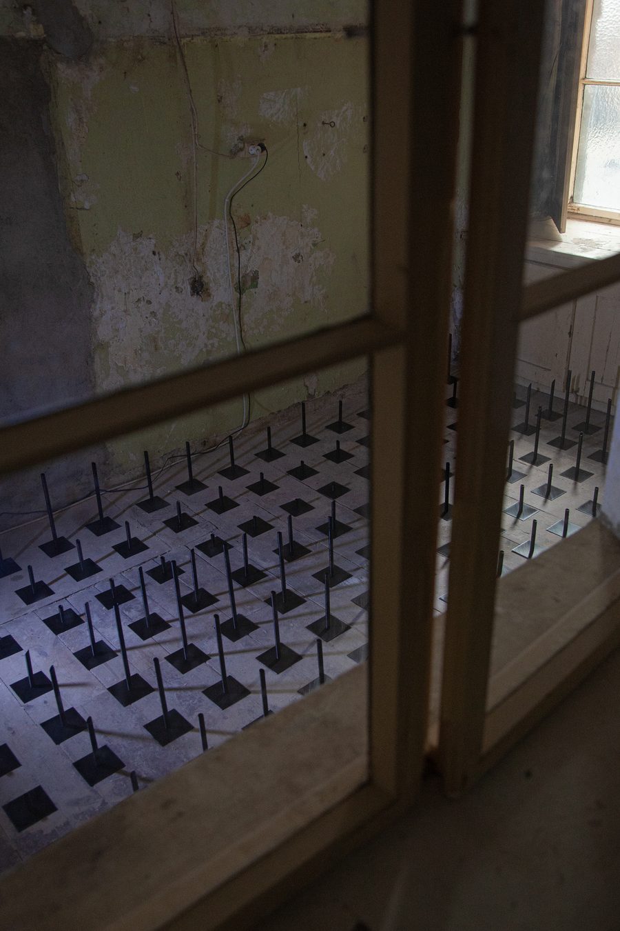 A wider view of the room, peeling walls, the field covering the floor