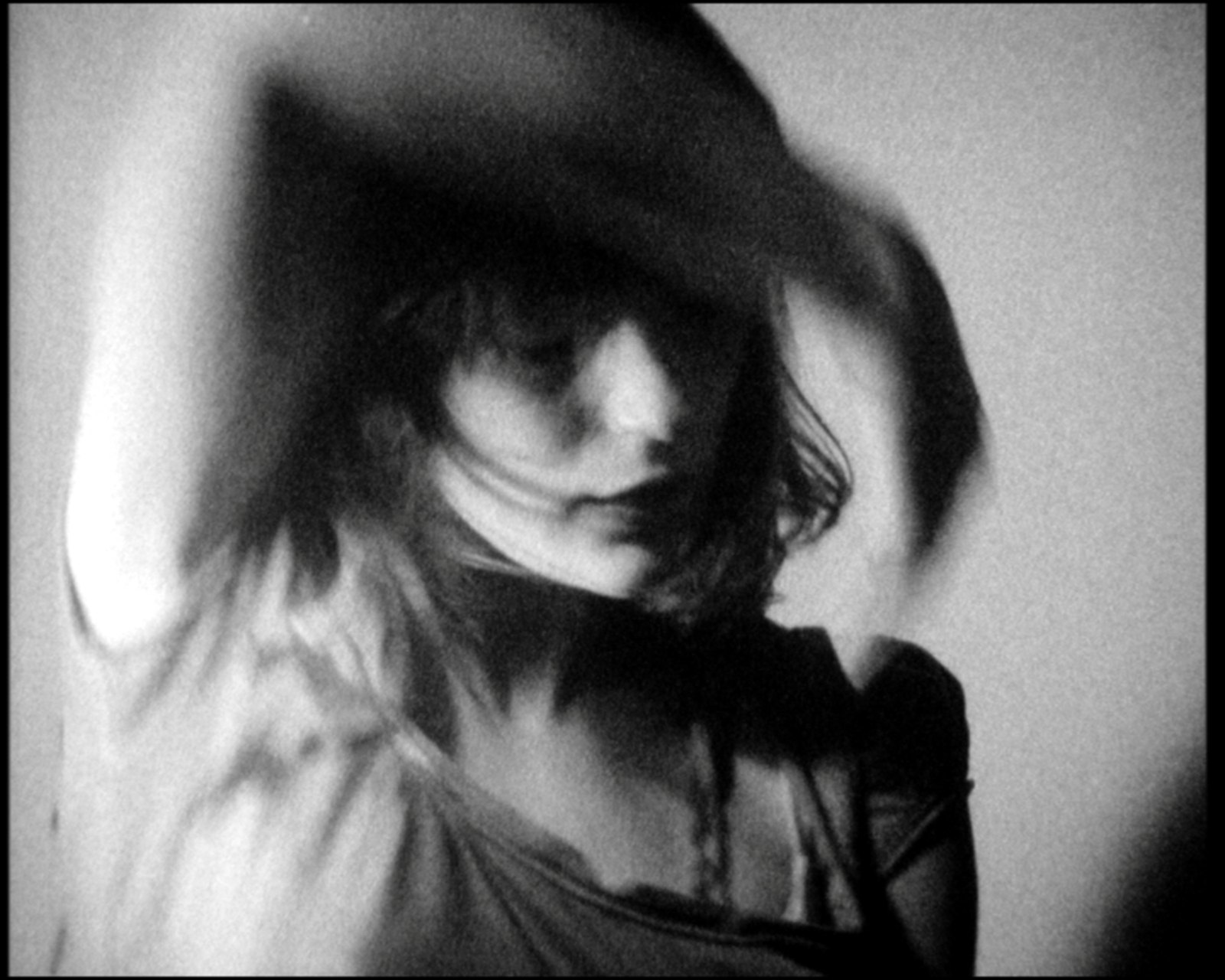 Her face and a raised arm blurred into one sweep of motion, hair across the eyes