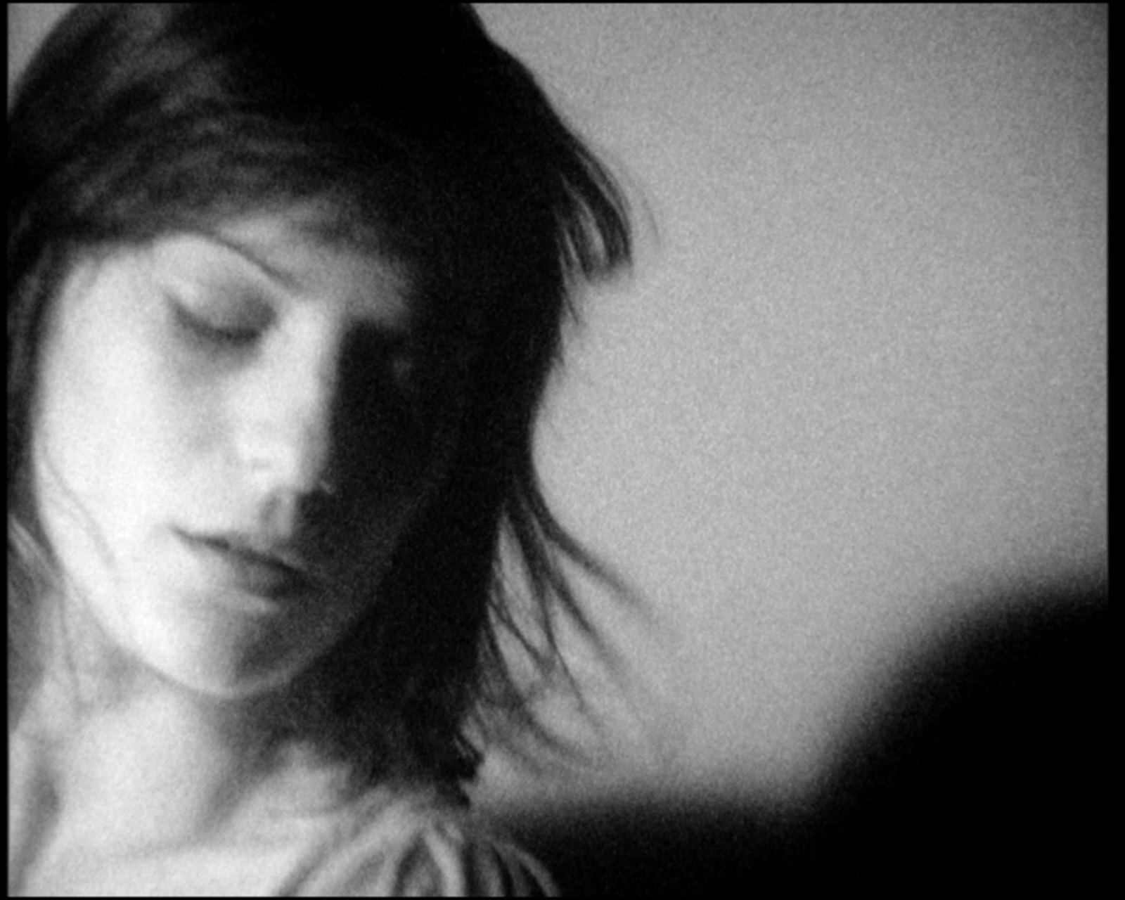 Her face close to the lens, eyes closed, hair fanning out to the right
