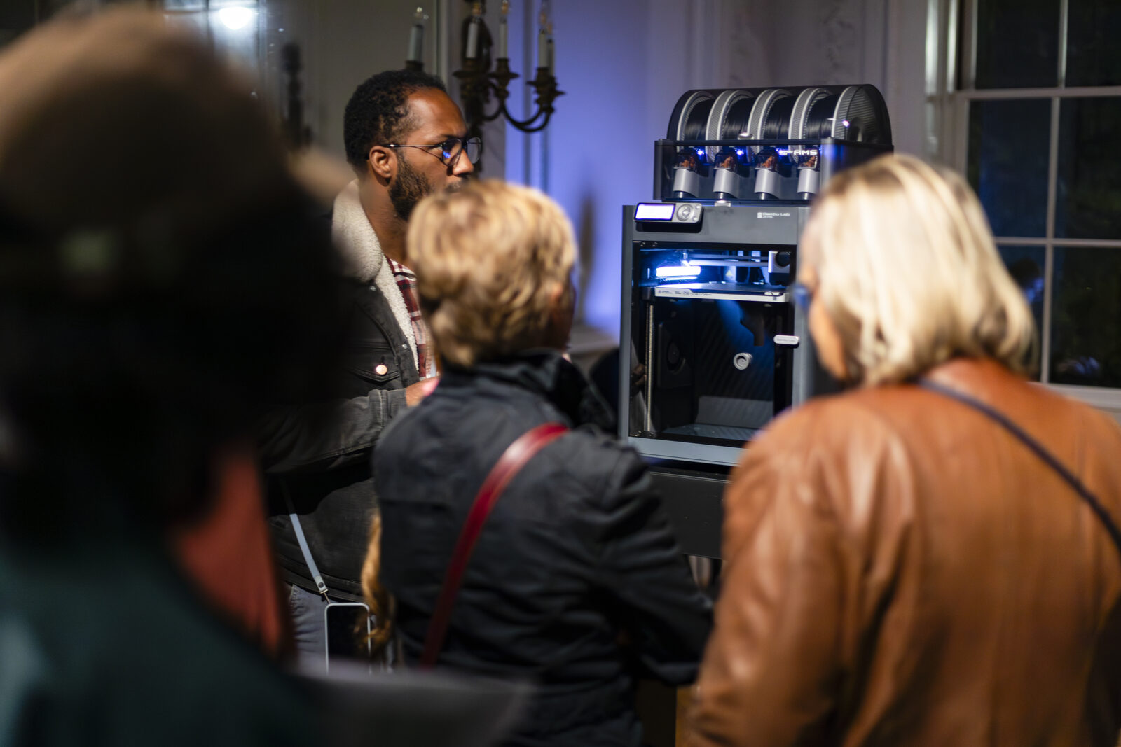 Visitors gathered close around one of the printers, watching the chamber as it works