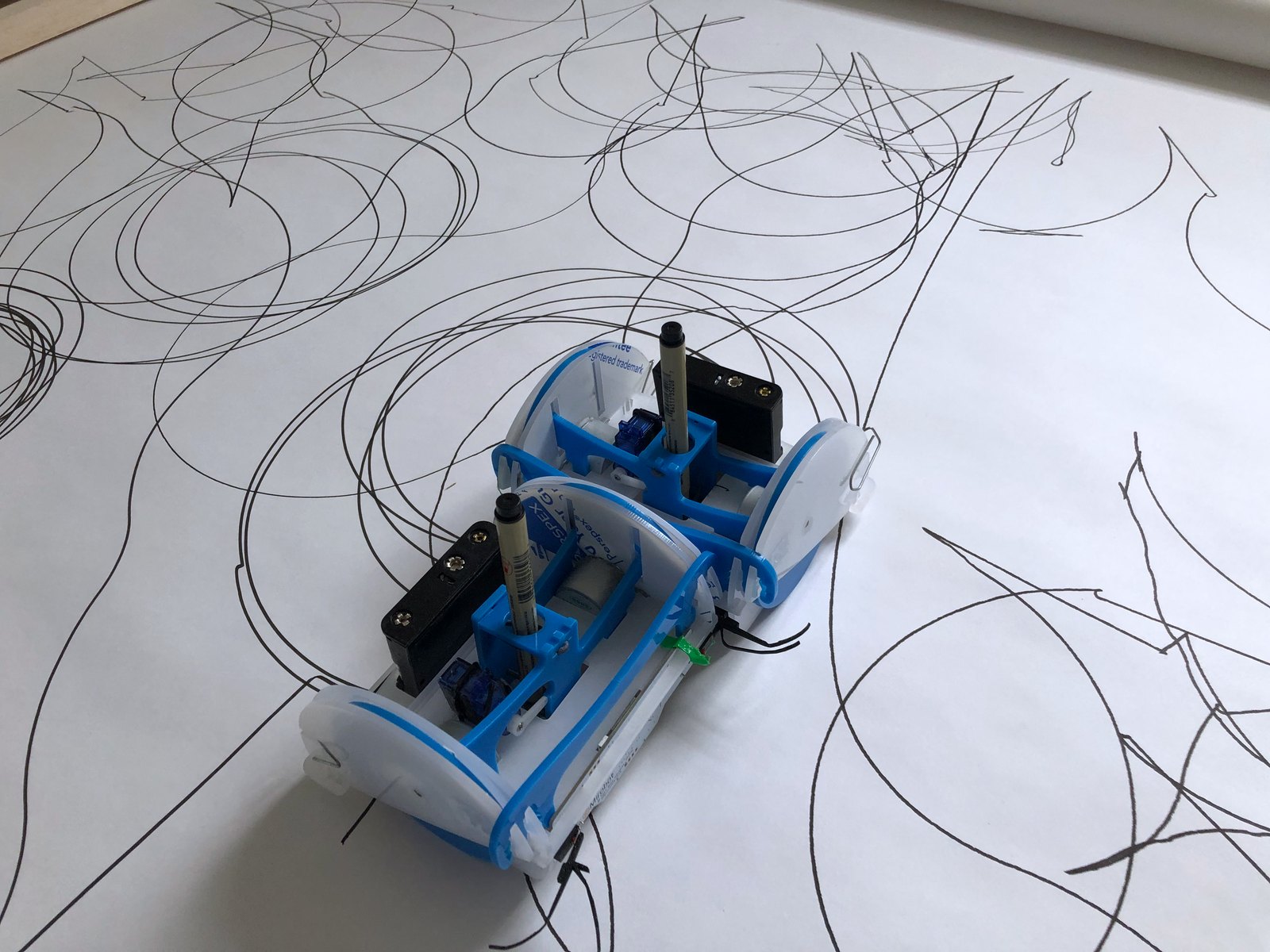 The two robots pressed side by side in a dense field of overlapping circles and lines, seen from above